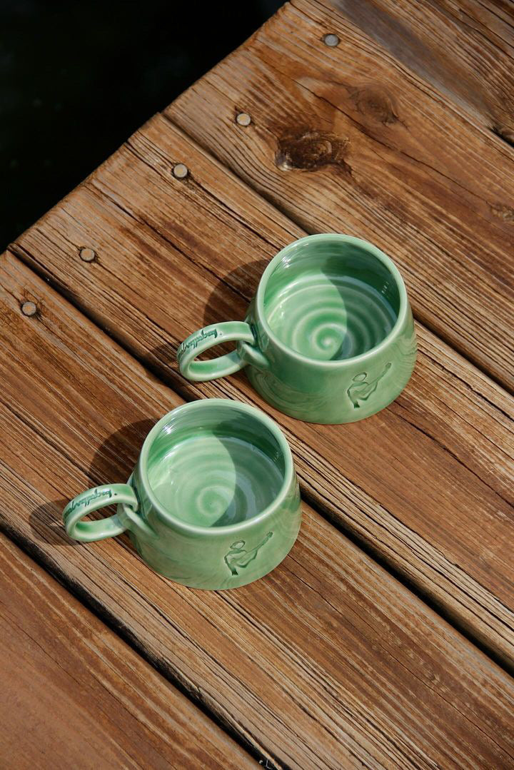 two handmade ring mugs with elvish text and swirl bottom