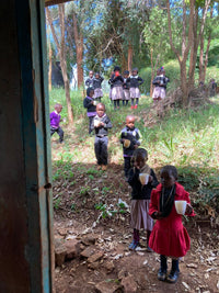 kids in nyeri kenya holding cups of water